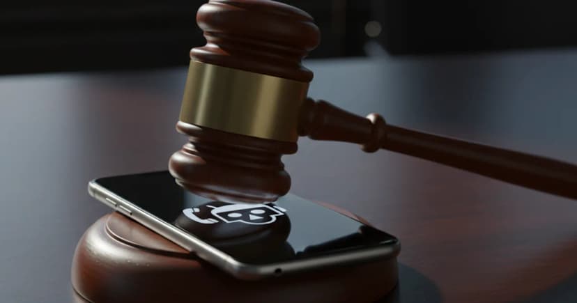 A sleek smartphone sits on a dark, polished mahogany desk, its screen glowing dimly with a simple white icon of a robot head integrated with a telephone